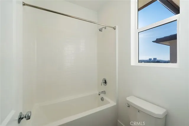 a bath room with a toilet and a bath tub