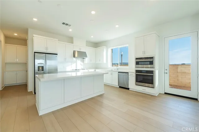 a kitchen with stainless steel appliances a refrigerator sink and cabinets