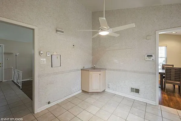 a view of a kitchen with fridge and an empty room