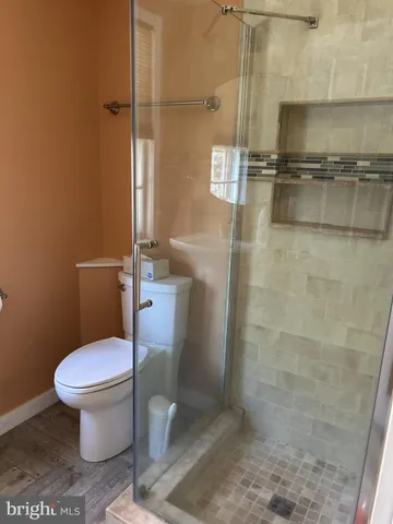 a white toilet sitting next to a shower