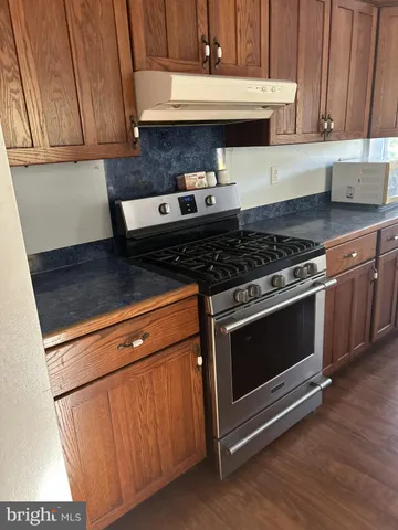 a kitchen with granite countertop a stove and a microwave