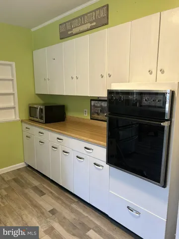 a kitchen with granite countertop white cabinets and white appliances