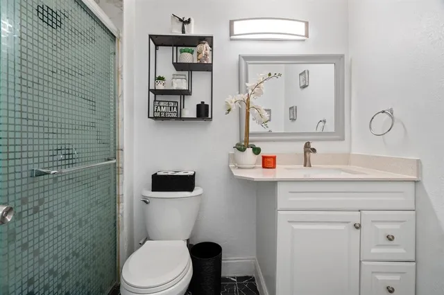 a bathroom with a toilet sink vanity and mirror