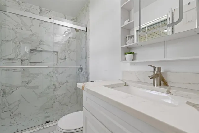 a bathroom with a sink a toilet and shower