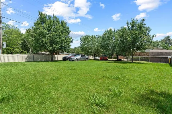 a view of green field with tree in the background