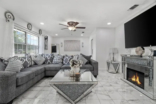 a living room with furniture a flat screen tv and a fireplace
