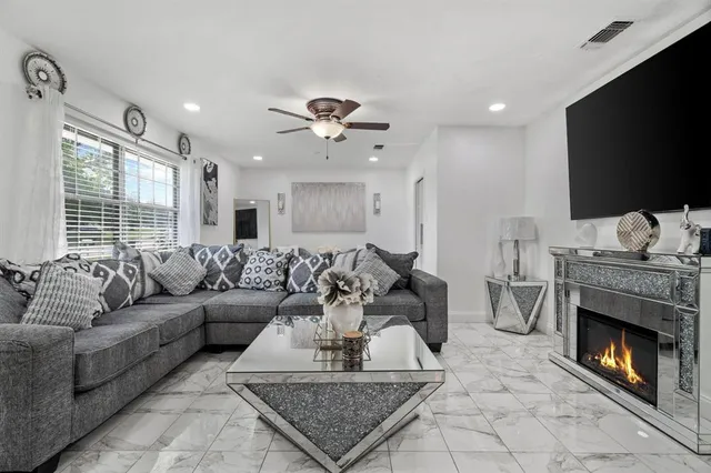 a living room with furniture a flat screen tv and a fireplace