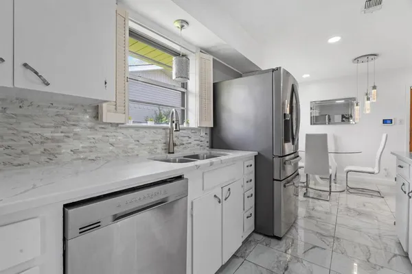 a kitchen with stainless steel appliances a sink cabinets and a refrigerator