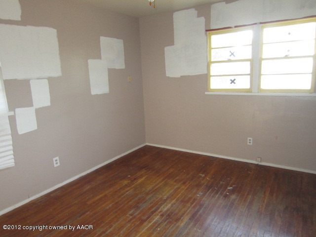 5122 South Bonham Street Amarillo, TX 79110 - Photo 3 of 15 an empty room with wooden floor and windows