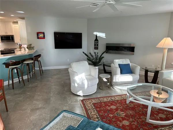 a living room with furniture a large window and a chandelier
