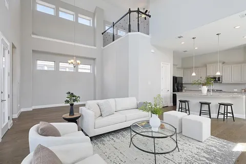 a living room with furniture kitchen view and a chandelier