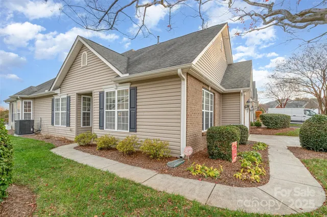 a front view of a house with a yard and potted plants