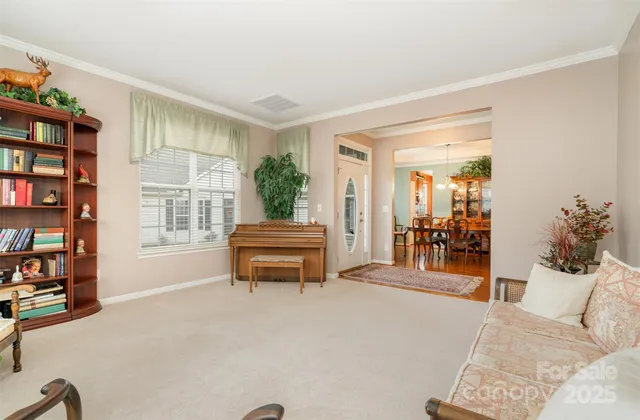 a living room with furniture a bookshelf and a window