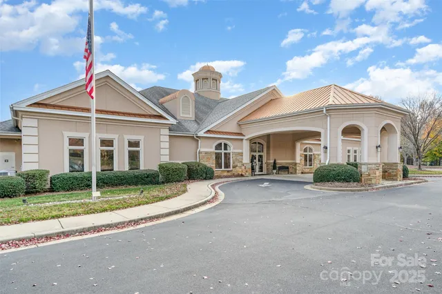 a view of a white house with a large windows and a large tree