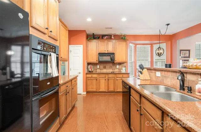 a large kitchen with kitchen island granite countertop a large window and stainless steel appliances