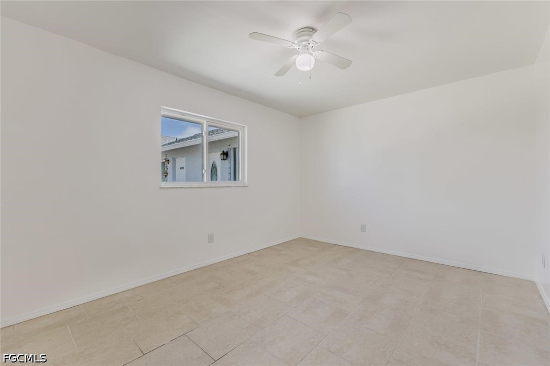 16595 Davis Road Fort Myers, FL 33908 - Photo 23 of 31 an empty room with a chandelier fan and windows