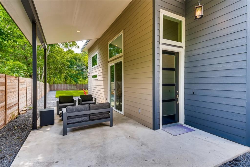 1142 Eleanor Street, Unit 2 Austin, TX 78721 - Photo 2 of 24 A spacious covered patio invites relaxation with a lush, fenced yard beyond.