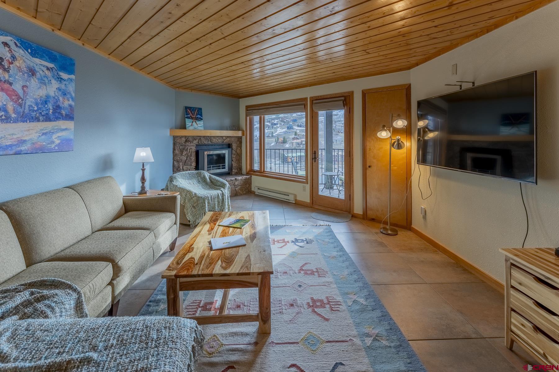 11 Morning Glory Way, Unit 14 Crested Butte, CO 81225 - Photo 11 of 44 a living room with furniture a flat screen tv and a fireplace
