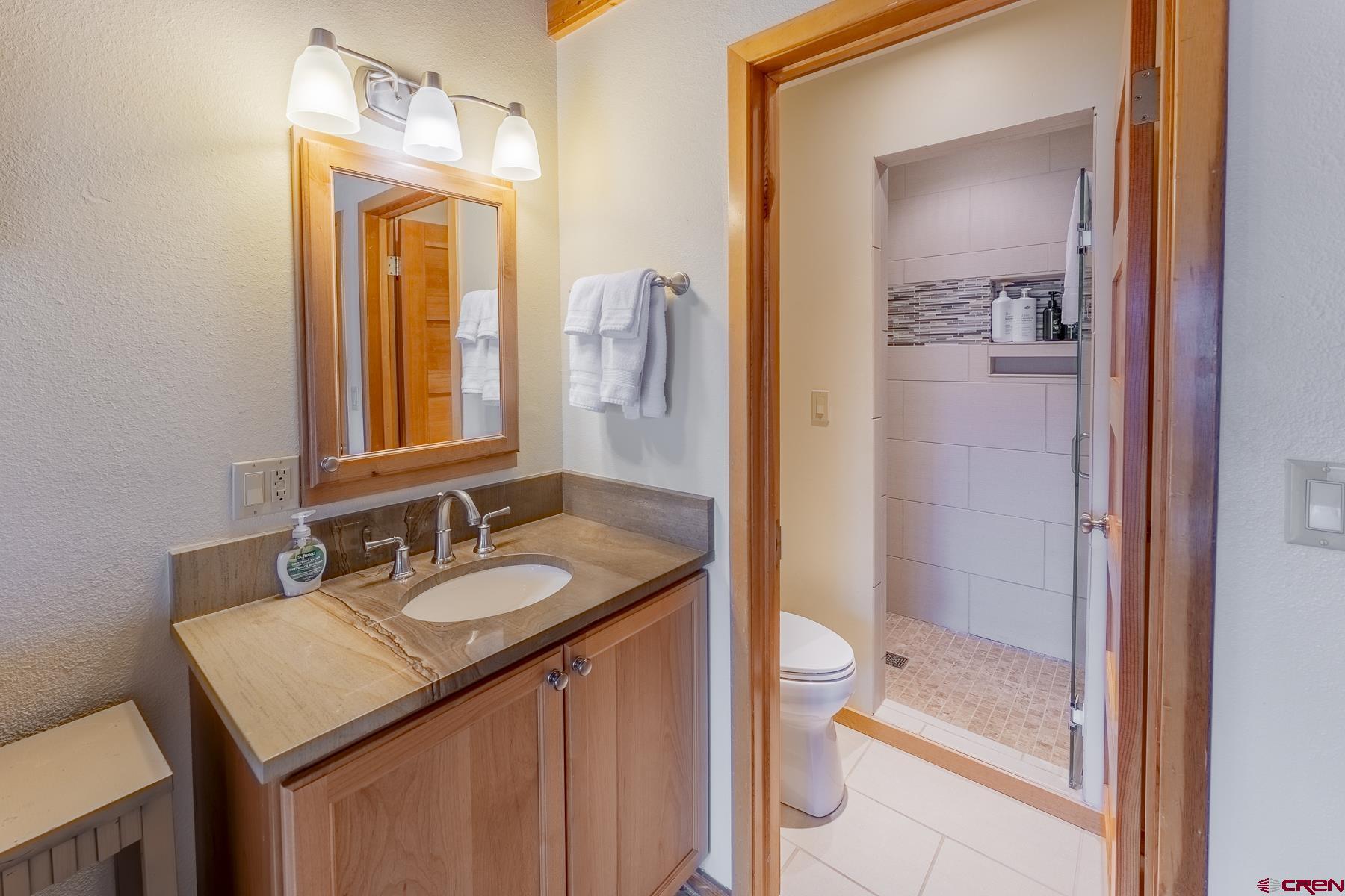 11 Morning Glory Way, Unit 14 Crested Butte, CO 81225 - Photo 24 of 44 a bathroom with a granite countertop sink and a mirror