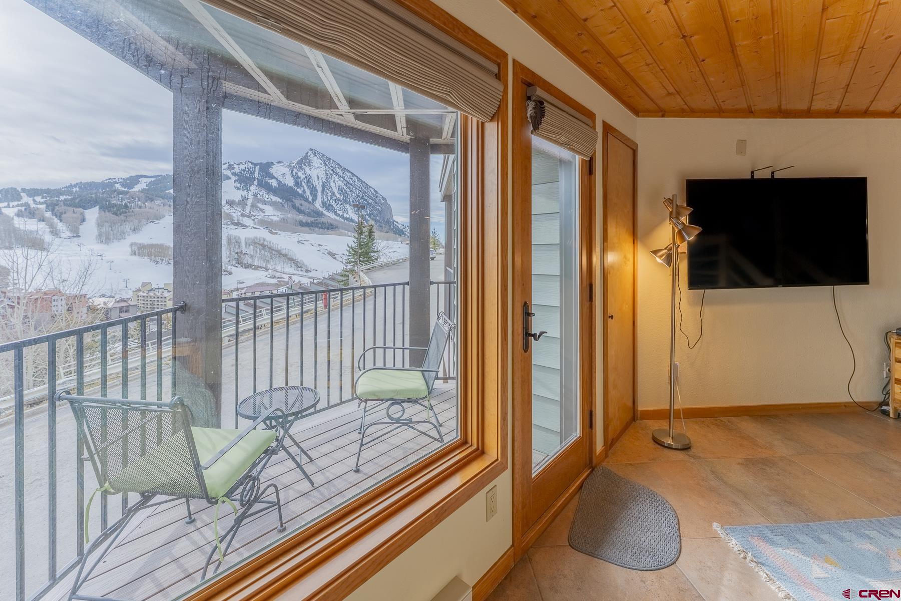11 Morning Glory Way, Unit 14 Crested Butte, CO 81225 - Photo 10 of 44 a living room with a flat screen tv and a floor to ceiling window