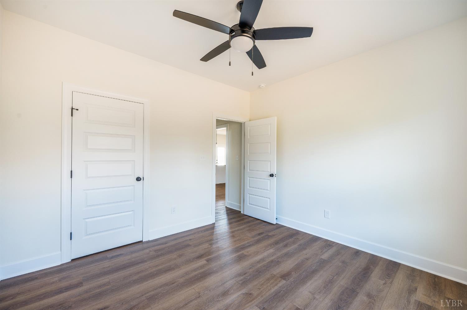 10578 Leesville Road Lynch Station, VA 24571 - Photo 33 of 54 an empty room with wooden floor ceiling fan and windows