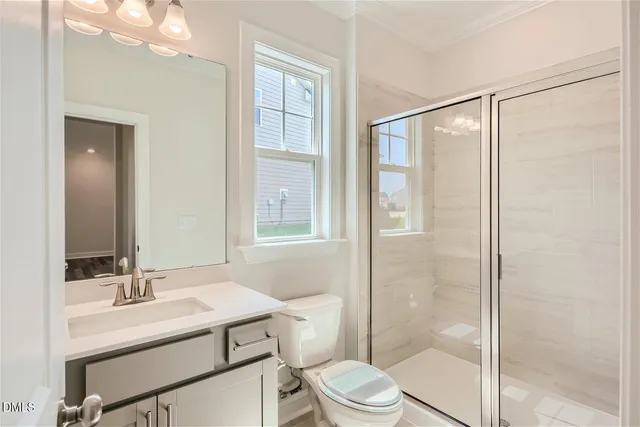 a bathroom with a sink toilet vanity and shower