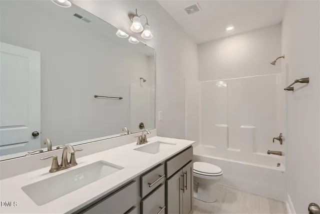 a bathroom with a toilet a sink a mirror and a shower