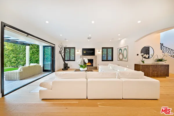 a living room with furniture large window and flat screen tv