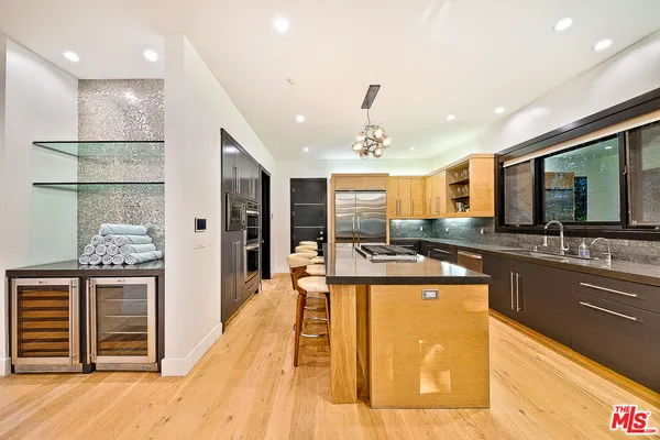 a kitchen with stainless steel appliances granite countertop a sink and a refrigerator