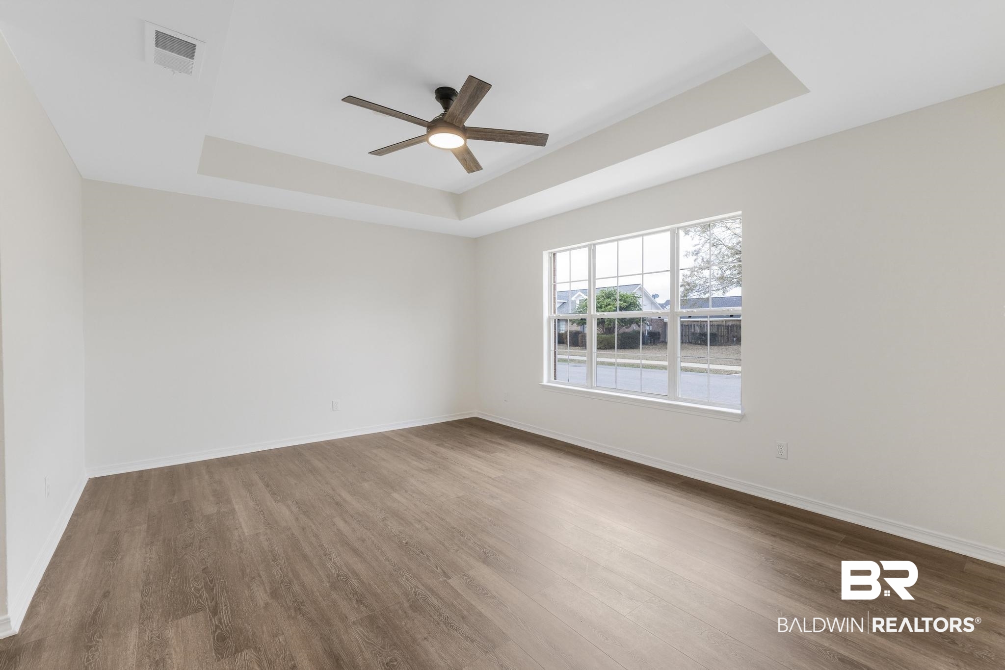 16330 Absalom Street Foley, AL 36535 - Photo 13 of 42 Unfurnished room with dark hardwood / wood-style floors, ceiling fan, and a tray ceiling