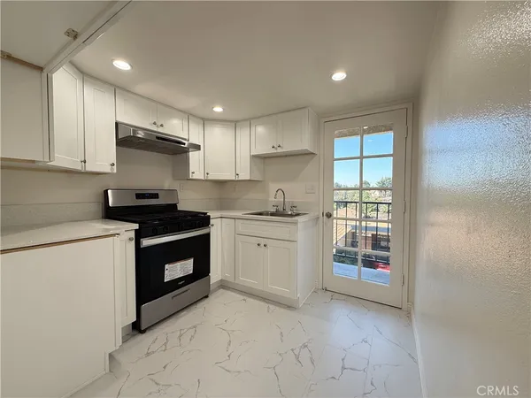 a kitchen with stainless steel appliances granite countertop a stove a sink and a refrigerator