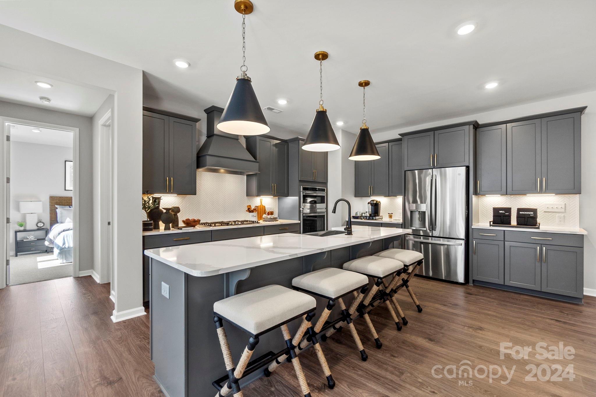 13229 Chopin Ridge Road Huntersville, NC 28078 - Photo 16 of 34 a open kitchen with stainless steel appliances granite countertop a kitchen island a stove a table and chairs