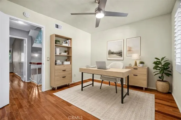 a view of a livingroom with furniture a ceiling fan and wooden floor