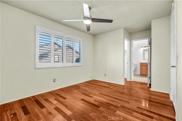 a view of a room with wooden floor and a ceiling fan