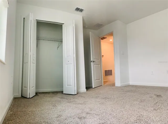 an empty room with closet and a bathroom