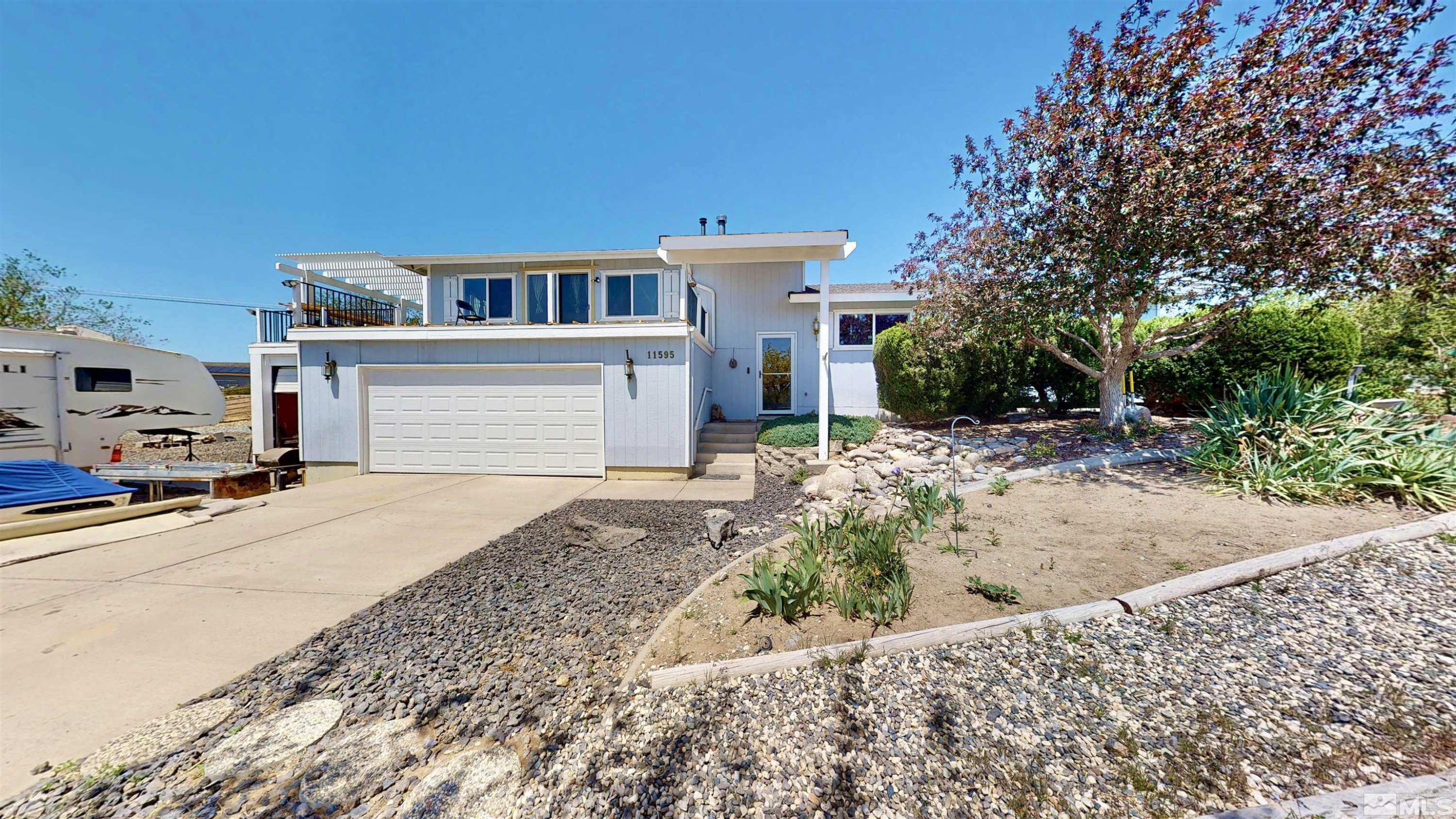 11595 Vicksburg Road Reno, NV 89508 - Photo 2 of 18 a front view of a house with a yard and garage