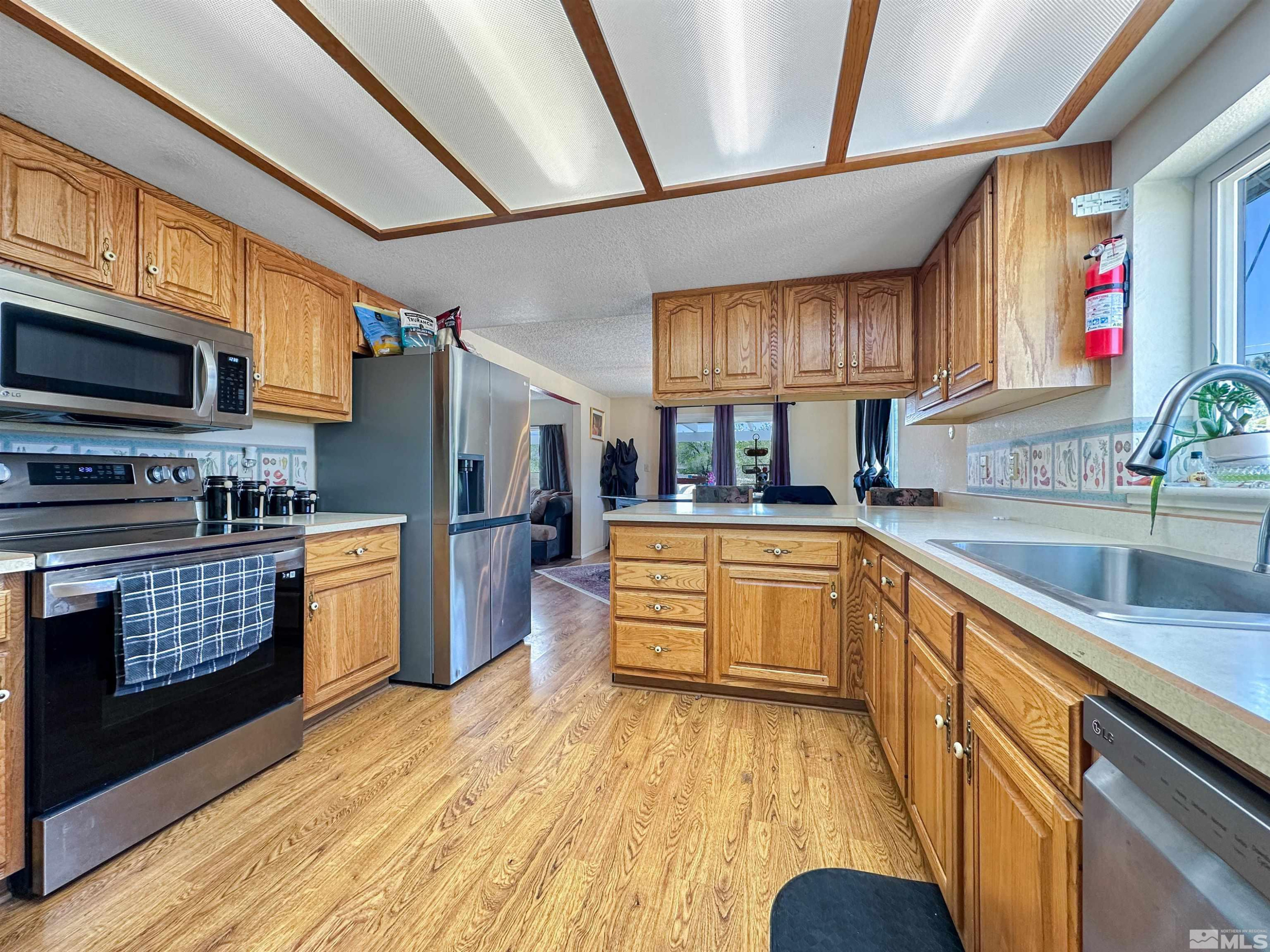 11595 Vicksburg Road Reno, NV 89508 - Photo 5 of 18 a kitchen with stainless steel appliances kitchen island granite countertop a stove a sink dishwasher and a microwave oven with cabinets