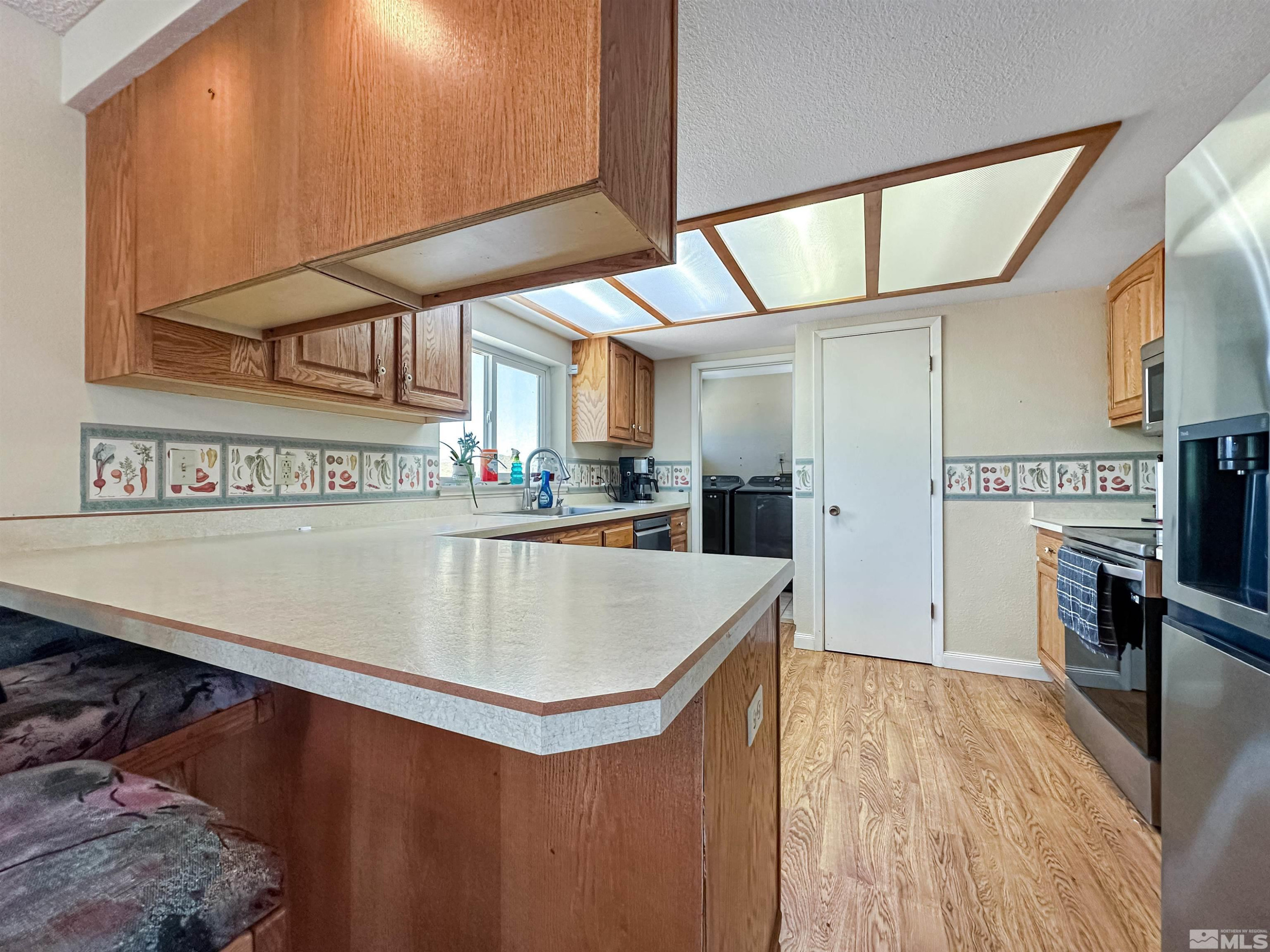 11595 Vicksburg Road Reno, NV 89508 - Photo 6 of 18 a kitchen with stainless steel appliances granite countertop a sink a stove counter space and cabinets
