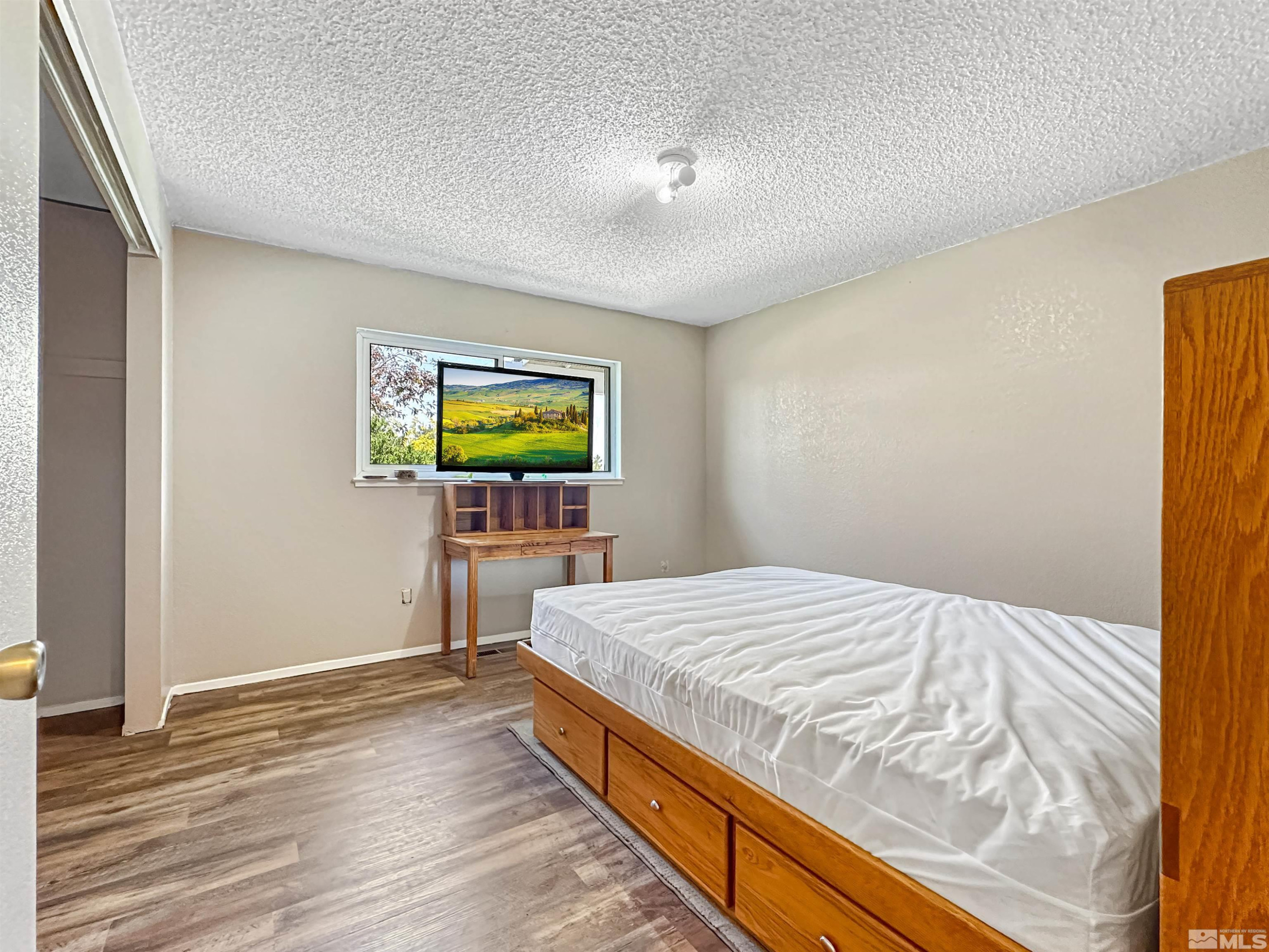 11595 Vicksburg Road Reno, NV 89508 - Photo 8 of 18 a bedroom with a bed and a flat screen tv