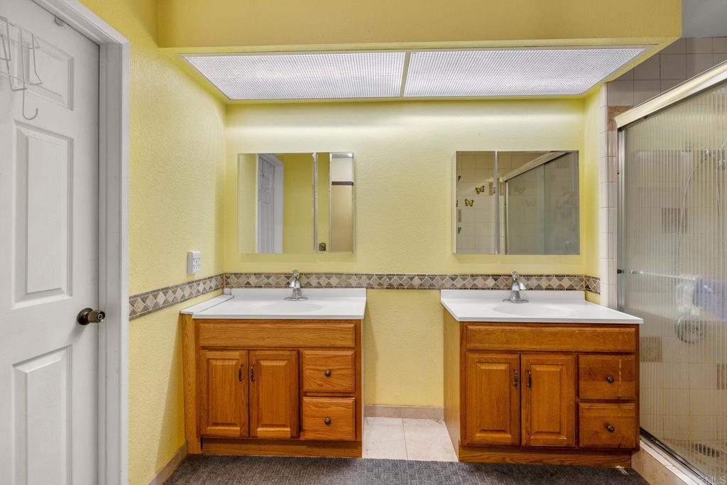 1518 Goldrush Way Oceanside, CA 92057 - Photo 15 of 36 a bathroom with a granite countertop sink a mirror a vanity and a bathtub