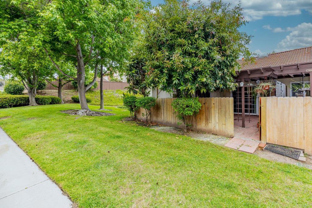 1518 Goldrush Way Oceanside, CA 92057 - Photo 21 of 36 a backyard of a house with plants and large tree