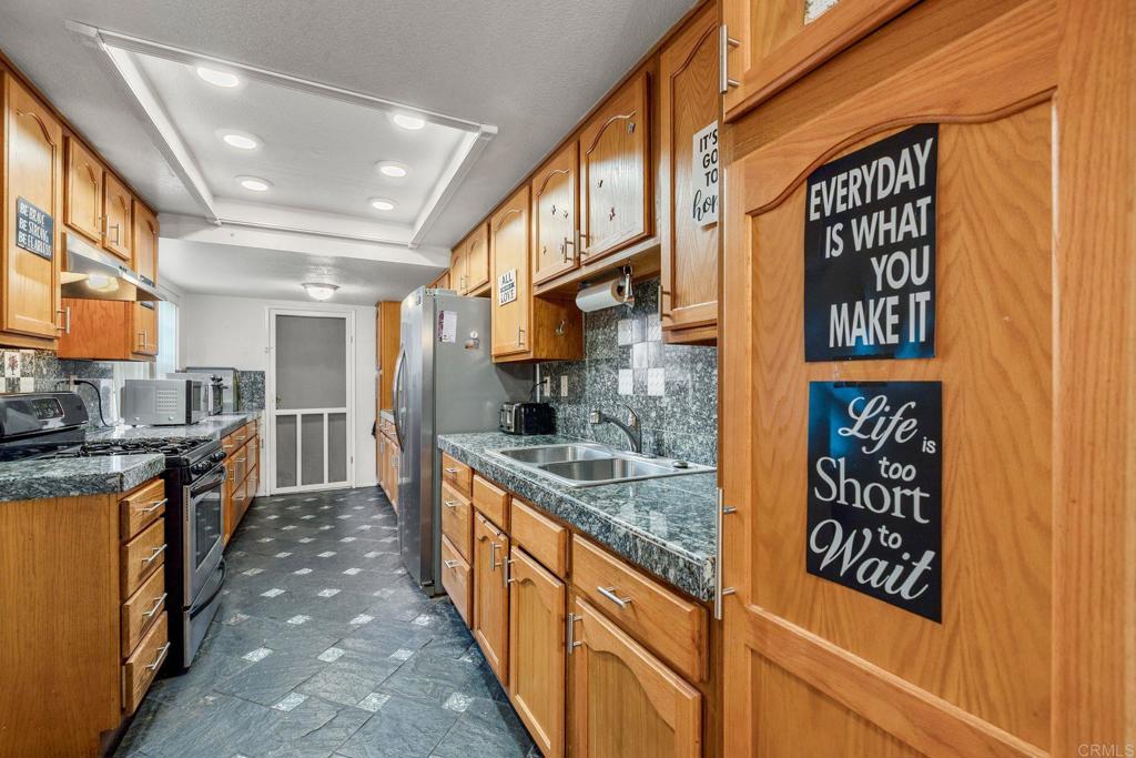 1518 Goldrush Way Oceanside, CA 92057 - Photo 8 of 36 a kitchen with stainless steel appliances granite countertop a sink and cabinets