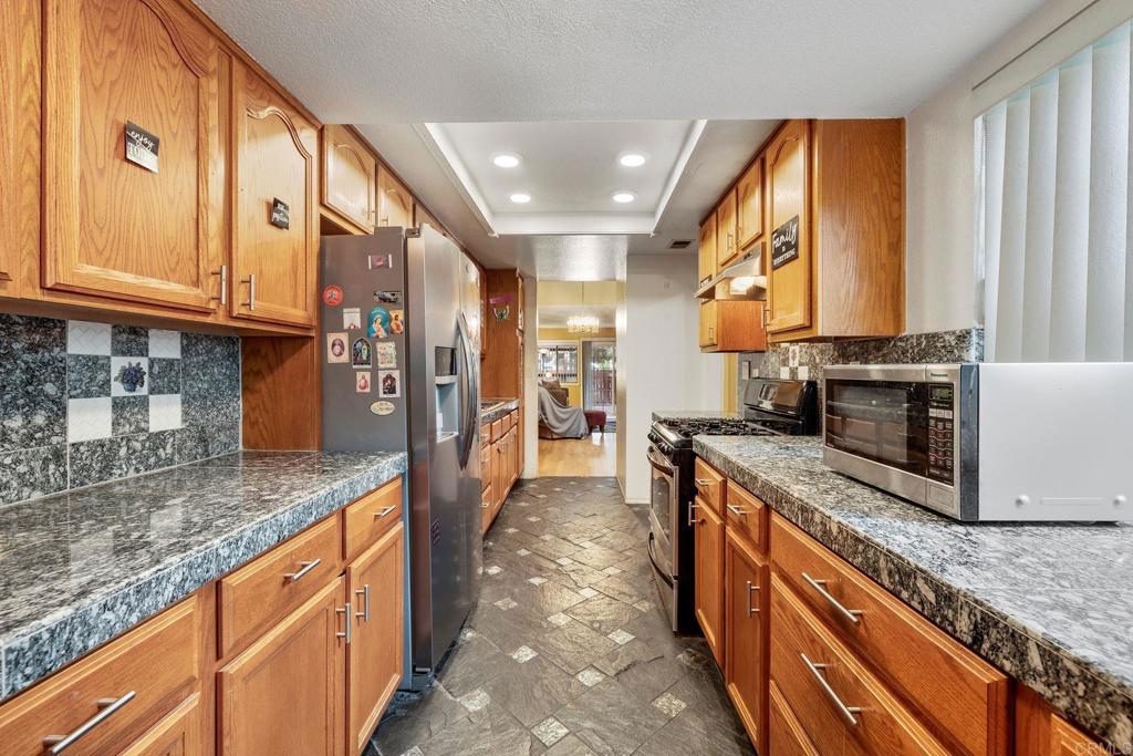 1518 Goldrush Way Oceanside, CA 92057 - Photo 10 of 36 a kitchen with stainless steel appliances granite countertop a stove a sink and a microwave