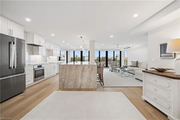 a large white kitchen with lots of counter top space stainless steel appliances and cabinets