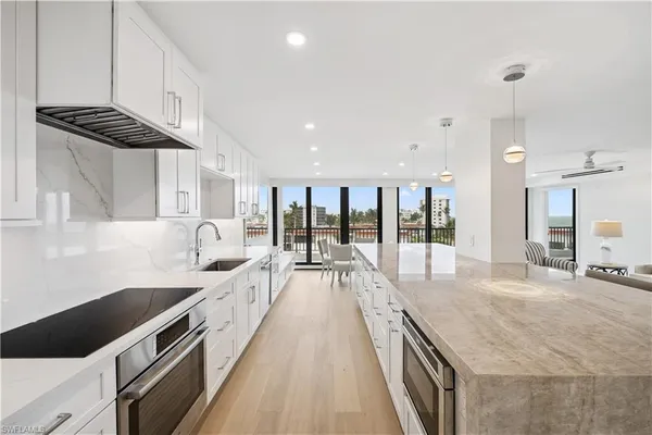 a large kitchen with kitchen island a large counter space a sink and appliances