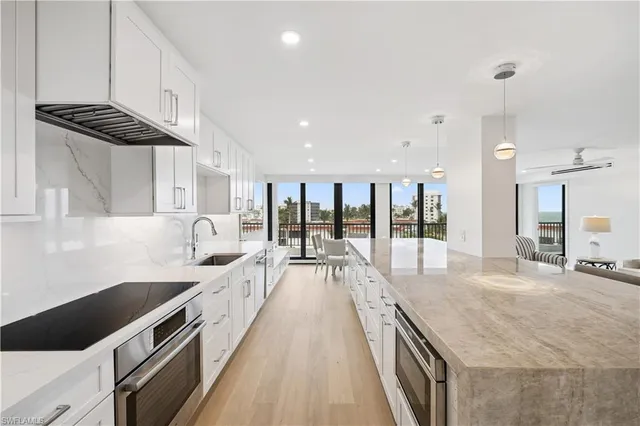 a large kitchen with kitchen island a large counter space a sink and appliances