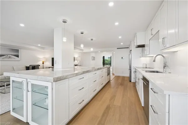 a large kitchen with stainless steel appliances kitchen island granite countertop a sink and cabinets