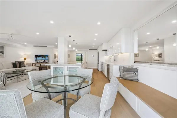 a dining room with furniture a table and kitchen view