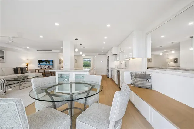 a dining room with furniture a table and kitchen view