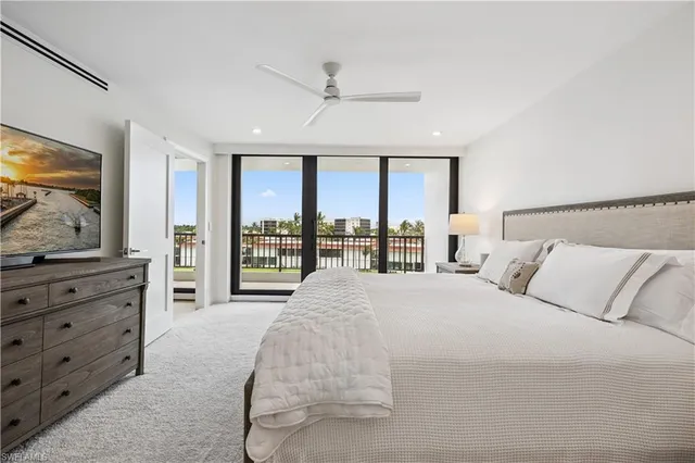 a bedroom with a large bed and a flat tv screen on dresser